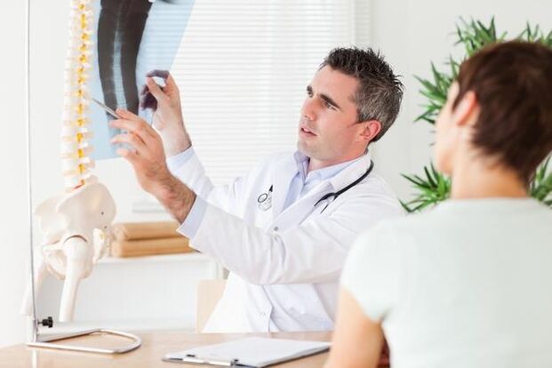 Der Arzt zeigt die Schädigung der Wirbelsäule durch zervikale Osteochondrose